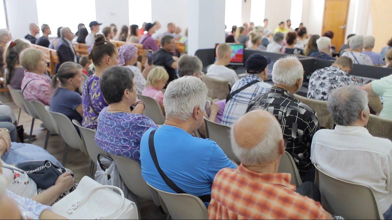 Menschen aus der Ukraine sitzen in der Gemeinde.